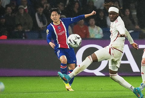 PSG's Lee Kang-in, right, attempts a shot on goal during the French League One soccer match between Paris Saint Germain and Brest in Paris, France.