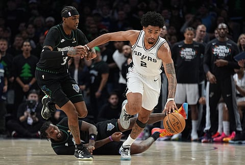 San Antonio Spurs guard Dylan Harper (2) moves the ball up court past Minnesota Timberwolves forward Jaden McDaniels (3) and center Naz Reid (11) during the second half of Game 4 of an NBA basketball second-round playoffs series in Minneapolis.