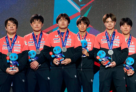 Silver medalists Japan stand on the podium after securing second place in the Men's Final at the World Team Table Tennis Championships in London.