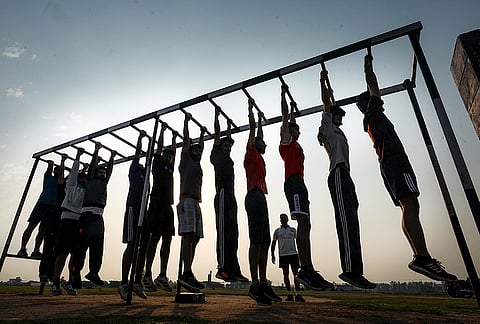 Aspirants perform a physical exercise while preparing for an Army recruitment rally, near the India-Pakistan border outskirts in Jammu.