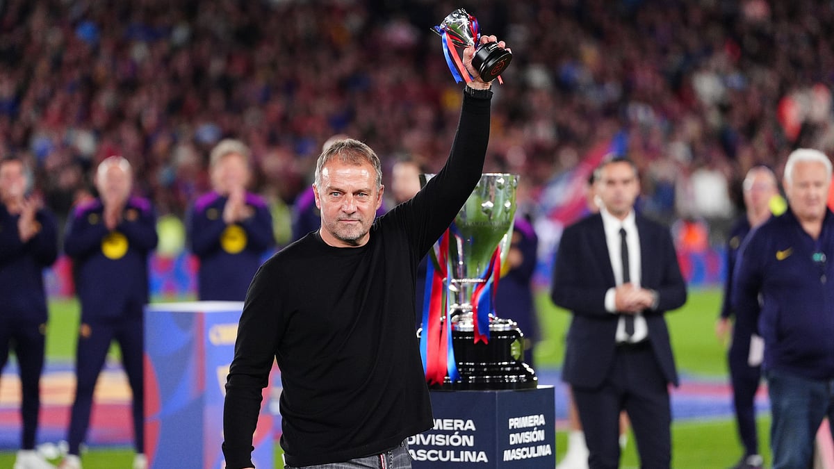 Barcelona head coach Hansi Flick lifts his award to the sky celebrating after defeating Real Madrid 2-0 to win the Spanish La Liga soccer championship with three rounds to spare, in Barcelona, Spain, Sunday, May 10, 2026.  - | Photo: AP/Joan Mateu Parra