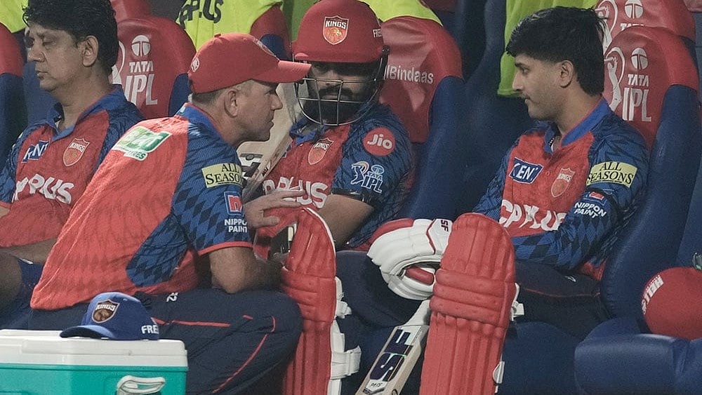 Punjab Kings' coach Ricky Ponting, squatting left,  speaks to Punjab Kings' openers Prabhsimran Singh, center, and Priyansh Arya before the Indian Premier League cricket match between Delhi Capitals and Punjab Kings in Dharamshala, India. - Photo: AP/Ashwini Bhatia