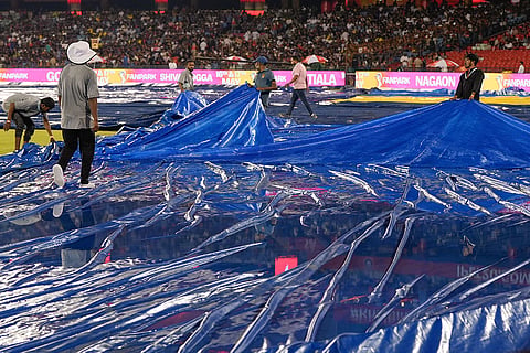 Ground staff remove the covers after rain stopped before an Indian Premier League (IPL) 2026 T20 cricket match between Royal Challengers Bengaluru and Kolkata Knight Riders, in Raipur, Chhattisgarh.