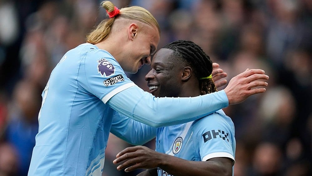 Manchester City's Jeremy Doku, right, celebrates with Manchester City's Erling Haaland after scoring the opening goal during the English Premier League soccer match between Manchester City and Brentford in Manchester. - | Photo: AP/Dave Thompson