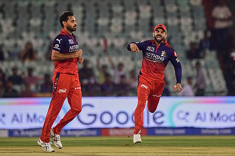 Royal Challengers Bengaluru's Virat Kohli, right and Bhuvneshwar Kumar celebrates the wicket of Kolkata Knight Riders' Finn Allen during the Indian Premier League cricket match between Royal Challengers Bengaluru and Kolkata Knight Riders in Raipur, India.