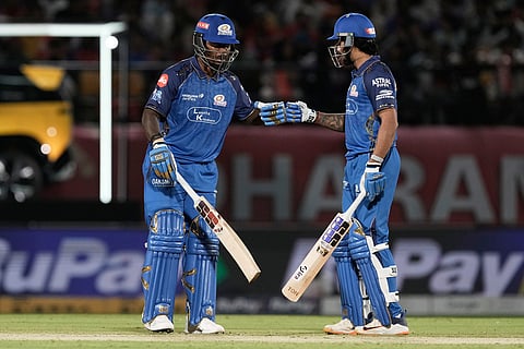 Mumbai Indians' Sherfane Rutherford, left, and batting partner Tilak Varma encourage each other during the Indian Premier League cricket match between Punjab Kings and Mumbai Indians in Dharamshala, India.