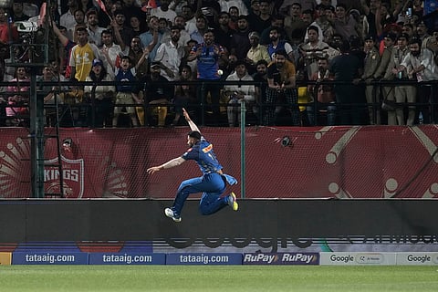 Mumbai Indians’ Naman Dhir dives to make an unsuccessful attempt to save a six hit by Punjab Kings’ Azmatullah Omarzai during the Indian Premier League cricket match between Punjab Kings and Mumbai Indians in Dharamshala, India.