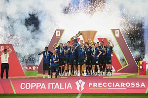 | Photo: AP/Andrew Medichini : Inter Milan's team captain Lautaro Martinez lifts the trophy while Inter Milan head coach Cristian Chivu at left celebrates after defeating Lazio to win the Italian Cup soccer final in Rome.