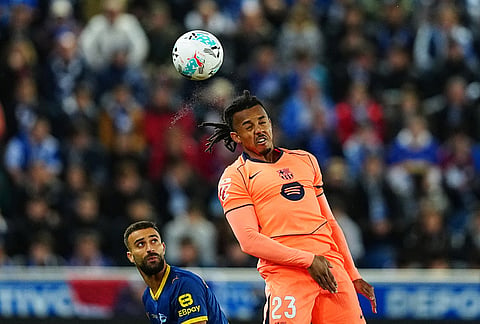 Barcelona's Jules Kounde heads the ball during the Spanish La Liga soccer match between Alaves and Barcelona in Vitoria-Gasteiz, Spain.