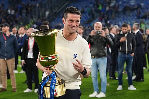 Inter Milan head coach Cristian Chivu poses with the trophy after defeating Lazio to win the Italian Cup soccer final in Rome.