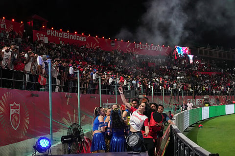 Punjab Kings co-owner Preity Zinta throws T-shirts to fans during the Indian Premier League cricket match between Punjab Kings and Mumbai Indians in Dharamshala, India.