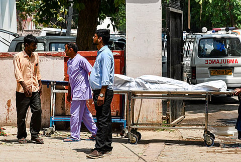 Family members of those who died after a strong storm and heavy rain, wait outside a mortuary of a hospital, in Prayagraj. At least 89 people were killed in the incident. 