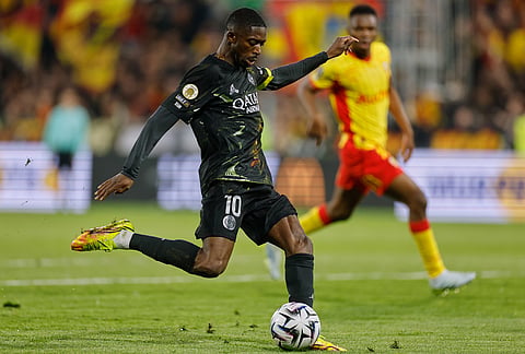 PSG's Ousmane Dembele kicks the ball during the French League One soccer match between Lens and Paris Saint Germain, in Lens, northern France.