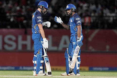 Mumbai Indians' Will Jacks, left, listens to batting partner Tilak Varma during the Indian Premier League cricket match between Punjab Kings and Mumbai Indians in Dharamshala, India