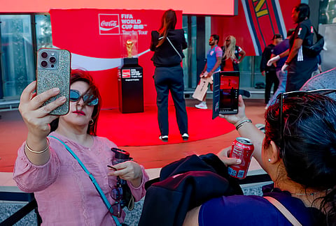 Soccer fans take photos of the trophy during the FIFA World Cup Trophy Tour before the Atlanta Braves host the Chicago Cubs in a baseball game, in Atlanta. 