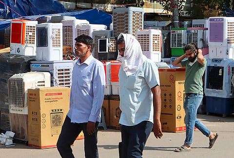 New Delhi: People walk past air coolers displayed for sale amid scorching heat at Kamla Market, in New Delhi. 