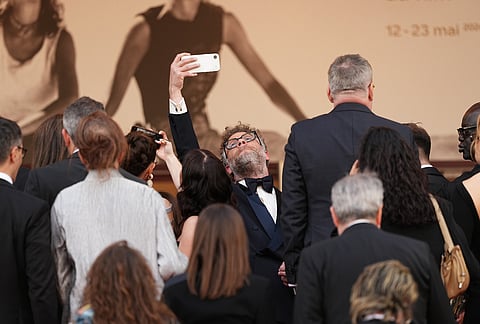 Seth Rogen takes a selfie photograph upon arrival at the premiere of the film 'Fatherland' at the 79th international film festival, Cannes, southern France.