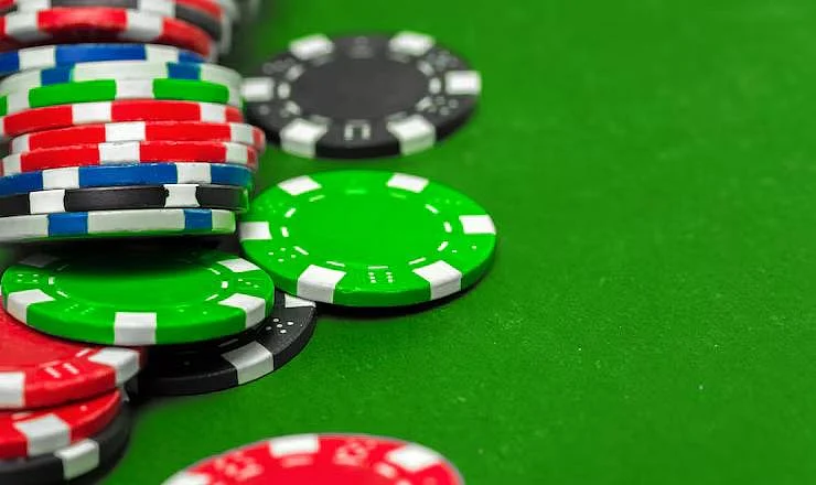 Colorful poker chips scattered on a green surface