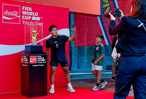 Soccer fans take photos of the trophy during the FIFA World Cup Trophy Tour before the Atlanta Braves host the Chicago Cubs in a baseball game, in Atlanta. 