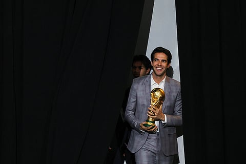 Former Brazilian soccer star Kaká, holding a World Cup trophy, enters for a panel on the 2026 FIFA World Cup soccer tournament halftime show during the Global Citizen NOW summit in New York.