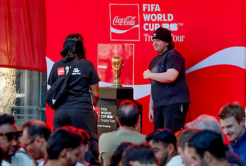 Soccer fans pose with the trophy during the FIFA World Cup Trophy Tour before the Atlanta Braves host the Chicago Cubs in a baseball game, in Atlanta.