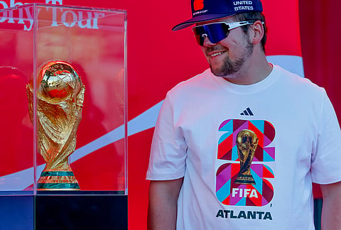 Soccer fan Joseph Pozdnakov has his photo taken during the FIFA World Cup Trophy Tour outside Truist Park before the Atlanta Braves host the Chicago Cubs in a baseball game, in Atlanta. 