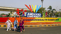 PTI : Commuters walk past newly-setup standees after the city was formally awarded hosting rights of the Commonwealth Games 2030, in Ahmedabad.