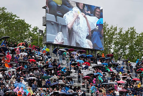 Spectators shelter from the rain during the quarter-final match between Karen Khachanov, of Russia, and Casper Ruud, of Norway, at the Italian Open tennis tournament in Rome.