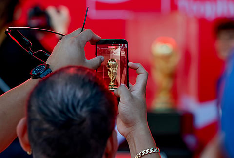 Soccer fans take photos of the trophy during the FIFA World Cup Trophy Tour before the Atlanta Braves host the Chicago Cubs in a baseball game, in Atlanta. 