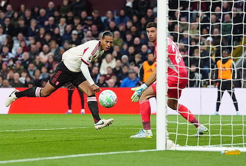 Liverpool's Virgil van Dijk, left, scores a goal during the English Premier League soccer match between Aston Villa and Liverpool in Birmingham, England.