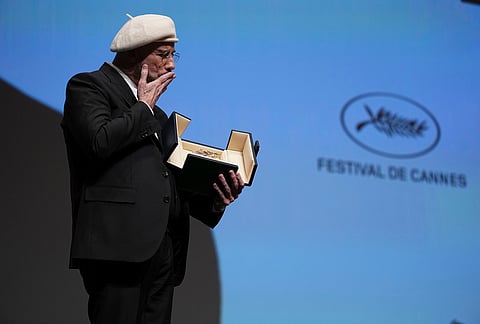 John Travolta holds his honorary Palme d'Or during the 79th international film festival, Cannes, southern France. 