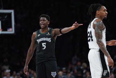 Minnesota Timberwolves guard Anthony Edwards (5) points to San Antonio Spurs guard Devin Vassell (24) as he questions a call during the first half of Game 6 of an NBA basketball second-round playoffs series in Minneapolis.