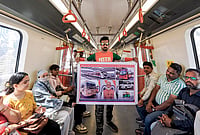 | Photo: PTI : Digital creator Arun Haryani holds a poster in a metro train, depicting use of public transport, to aware people about fuel conservation in view of Prime Minister Narendra Modi's appeal for austerity, in Ahmedabad, Gujarat.