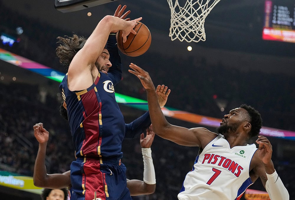 Cleveland Cavaliers guard Max Strus, left, reaches for the ball with Detroit Pistons forward Paul Reed (7) in the second half of Game 6 of a second-round NBA basketball playoffs series in Cleveland.  - | Photo: AP/Sue Ogrocki