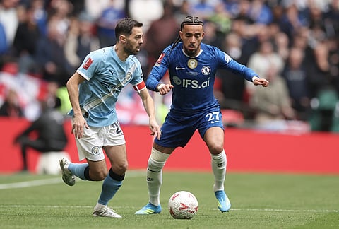 Manchester City's Bernardo Silva, left, and Chelsea's Malo Gusto challenge for the ball during the English FA Cup final soccer match between Chelsea and Manchester City in London.