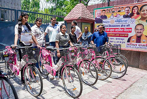 Students pose with bicycles distributed by Delhi Chief Minister Rekha Gupta, unseen, to those who cleared their Class 10th and 12th board examinations at the RK Puram Assembly constituency, in New Delhi. 