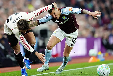 Aston Villa's Lucas Digne, right, and Liverpool's Federico Chiesa battle for the ball during the English Premier League soccer match between Aston Villa and Liverpool in Birmingham, England