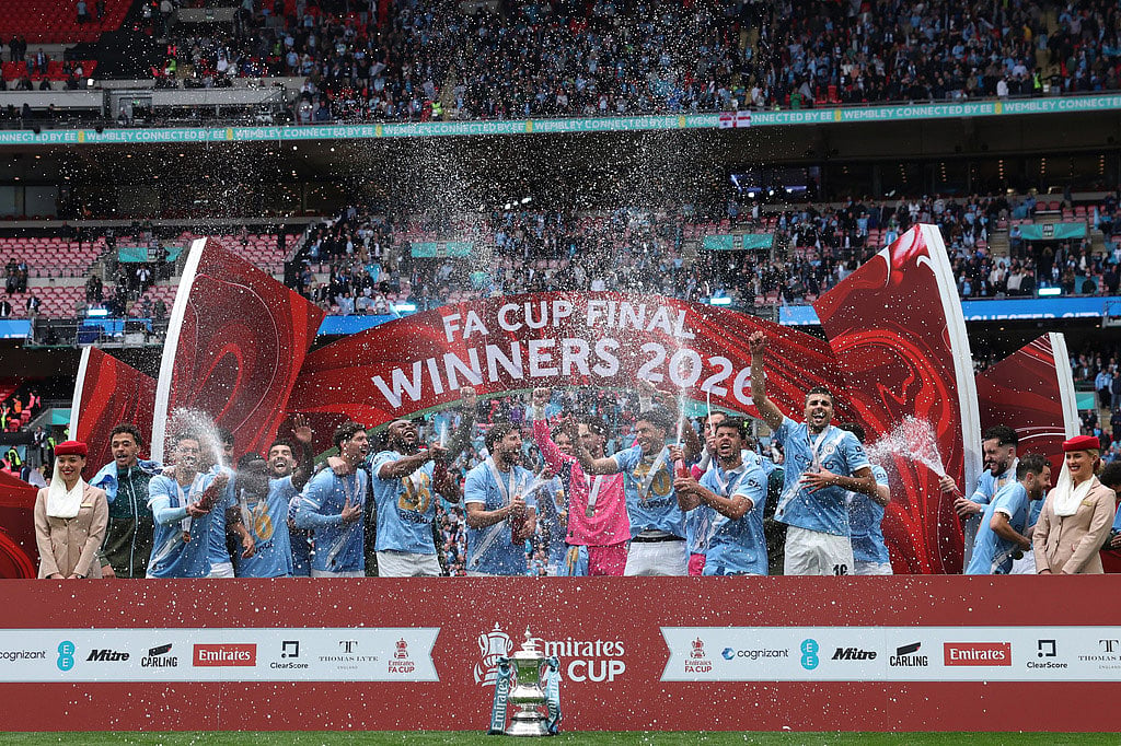 Manchester City players celebrate with the winner's trophy after the English FA Cup final soccer match between Chelsea and Manchester City in London. - | Photo: AP/Richard Pelham