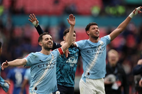 Manchester City's Bernardo Silva, left, celebrates with teammates after winning the English FA Cup final soccer match between Chelsea and Manchester City in London.