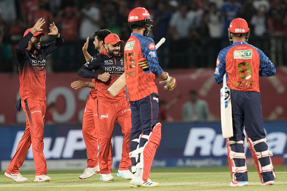 | Photo: AP/Ashwini Bhatia : Royal Challengers Bengaluru's Virat Kohli, third left, celebrates after his team won the match against Punjab Kings during the Indian Premier League cricket match in Dharamshala, India,.
