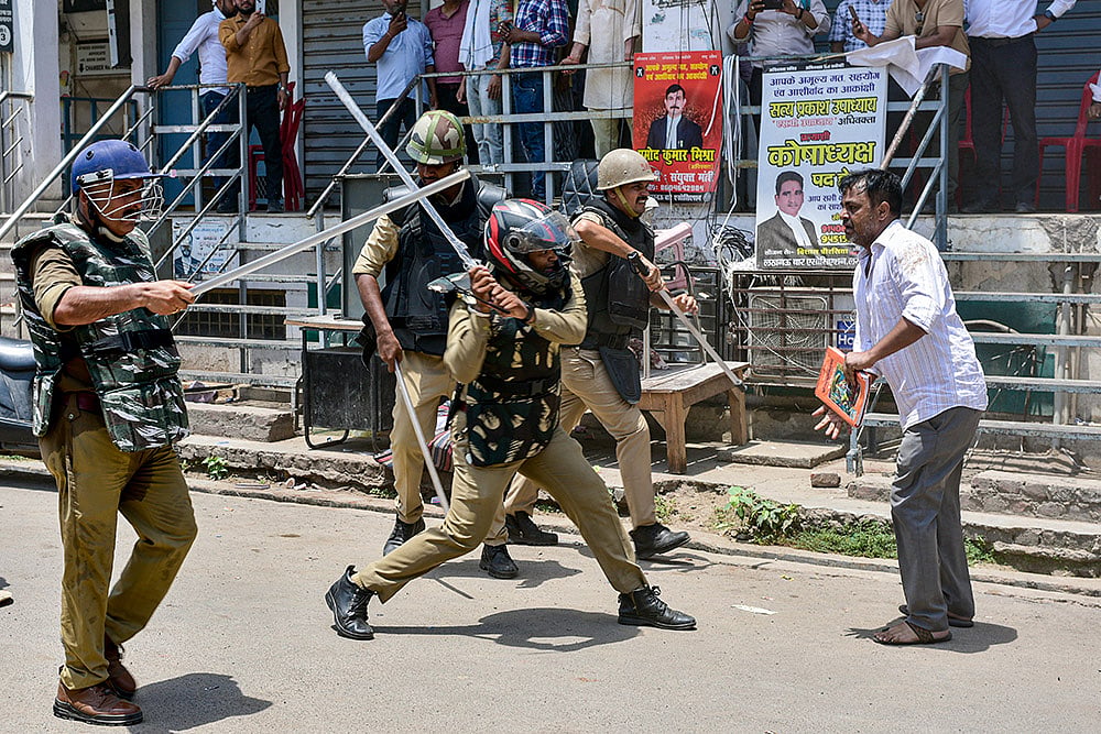 Police personnel conduct baton charge on a man protesting during an anti-encroachment drive on illegal lawyer chambers, conducted by Lucknow Municipal Corporation, Uttar Pradesh. - | Photo: PTI/Nand Kumar