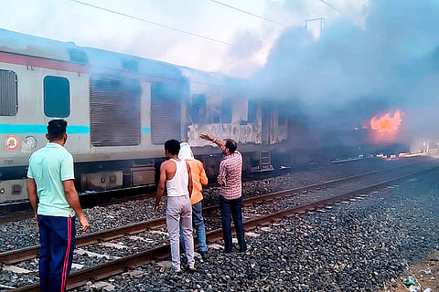 People gather after a fire broke out in an AC coach of the Thiruvananthapuram-Hazrat Nizamuddin Rajdhani Express in Madhya Pradesh's Ratlam district.