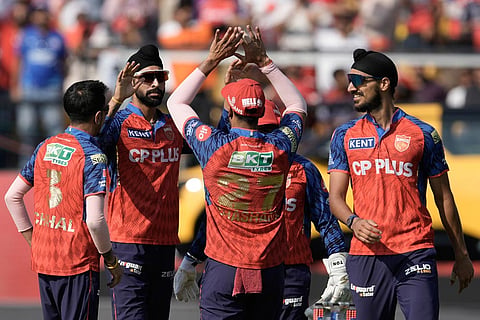 Punjab Kings' Harpreet Brar, second left, celebrates with teammates the wicket of Royal Challengers Bengaluru's Devdutt Padikkal during the Indian Premier League cricket match between Punjab Kings and Royal Challengers Bengaluru in Dharamshala, India.