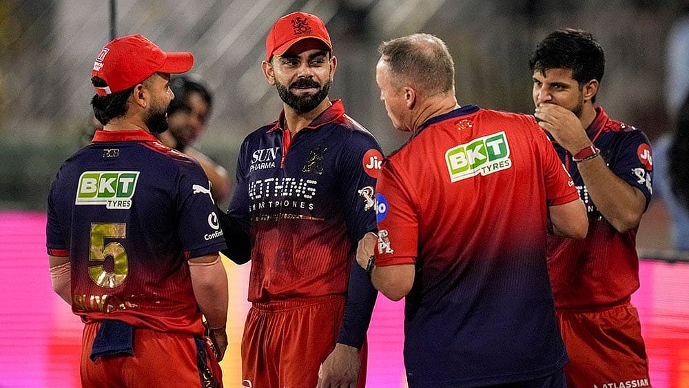 Raipur: Royal Challengers Bengaluru's Virat Kohli, centre, Suyash Sharma, left, and head coach Andy Flower, second left, during an Indian Premier League (IPL) 2026 T20 cricket match between Royal Challengers Bengaluru and Mumbai Indians, in Raipur, Chattisgarh. - | Photo: PTI/Atul Yadav