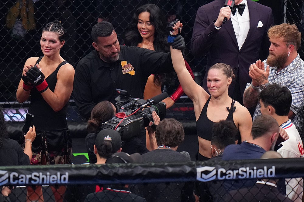 Ronda Rousey, of the United States, center, celebrates after defeating Gina Carano, of the United States, left, in their featherweight mixed martial arts fight in Inglewood, Calif.  - | Photo: AP/Jae C. Hong
