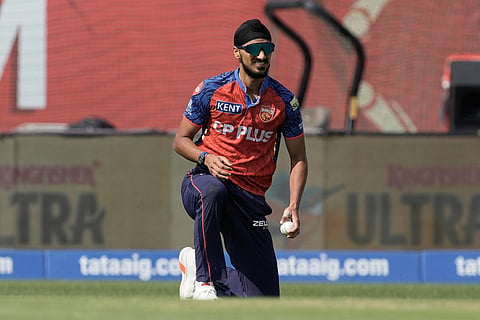 Punjab Kings' Arshdeep Singh reacts after drops a catch during the Indian Premier League cricket match between Punjab Kings and Royal Challengers Bengaluru in Dharamshala, India.