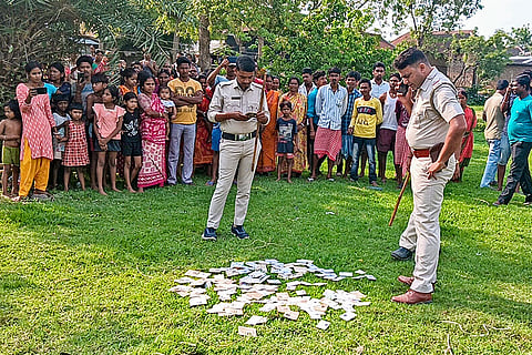 Police personnel conduct investigation after a large number of Electoral Photo Identity Cards (EPIC) were found scattered in a field, in Birbhum district, West Bengal.