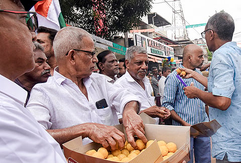 UDF workers distribute sweets on the day of the swearing-in ceremony of the Kerala government, in Kochi.