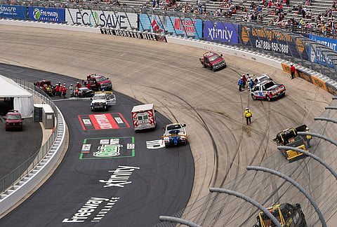 Crews work to clean the track after a multi-car wreck during the NASCAR All-Star auto race at Dover Motor Speedway, in Dover, Delaware. 