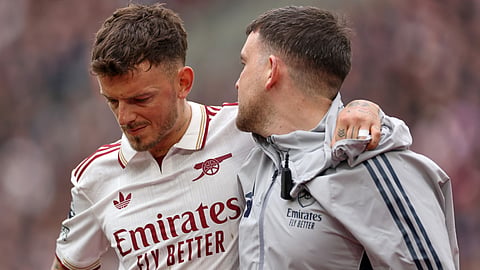 Arsenal's Ben White is helped off the pitch after getting injured during the English Premier League soccer match between West Ham and Arsenal in London, Sunday, May 10, 2026.